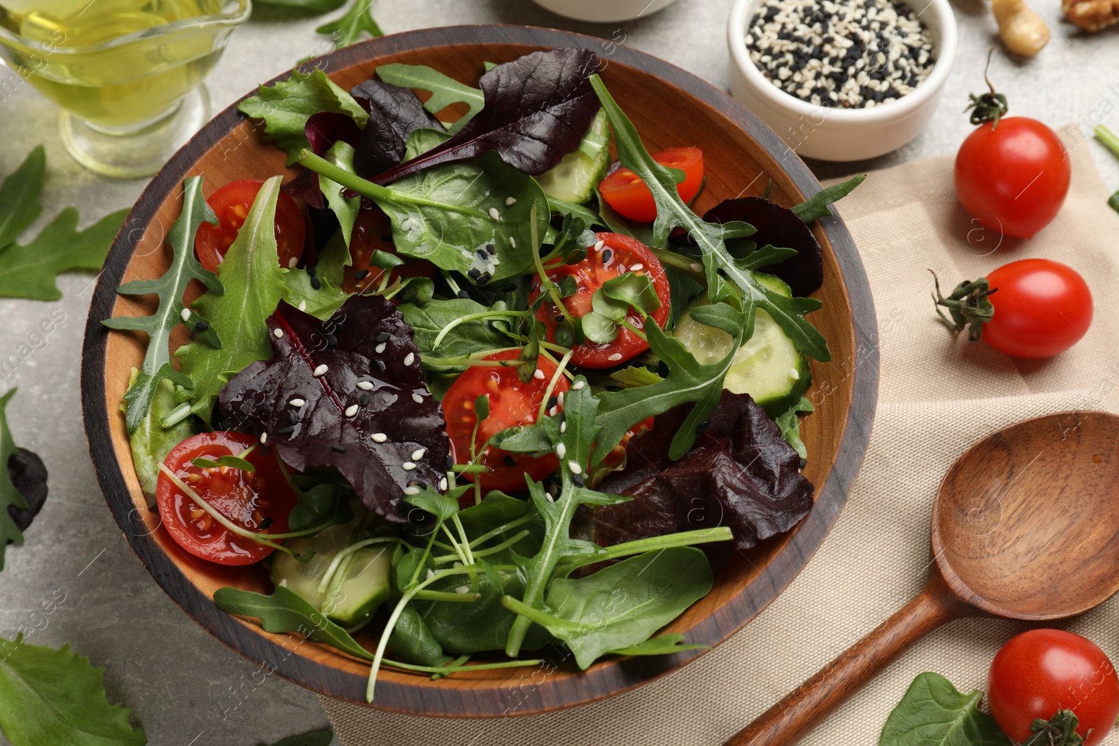 Photo of Tasty fresh vegetarian salad and ingredients on grey table, above view