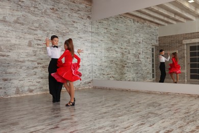 Photo of Beautifully dressed couple of kids dancing together in studio, space for text