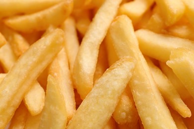 Photo of Many delicious French fry pieces as background, closeup