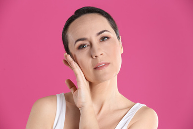 Photo of Portrait of beautiful mature woman on pink background