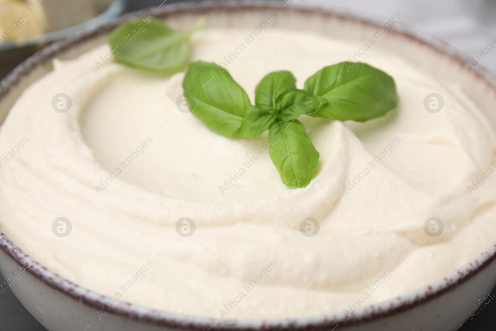 Photo of Delicious tofu sauce and basil leaves in bowl, closeup