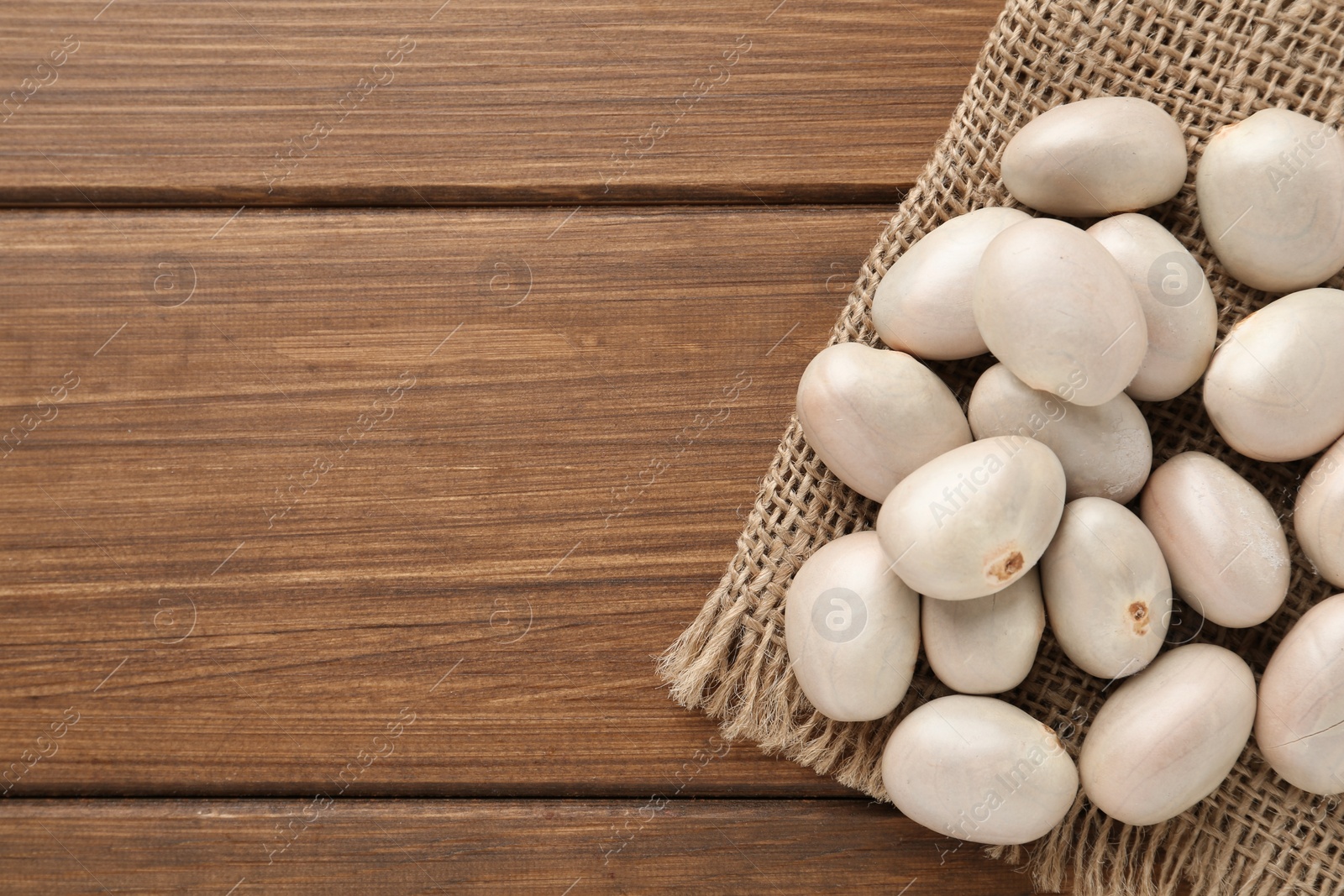 Photo of Raw jackfruit seeds on wooden table, top view. Space for text