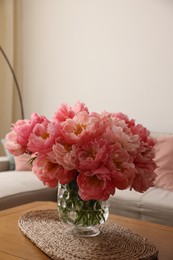 Beautiful pink peonies in vase on table at home, space for text. Interior design