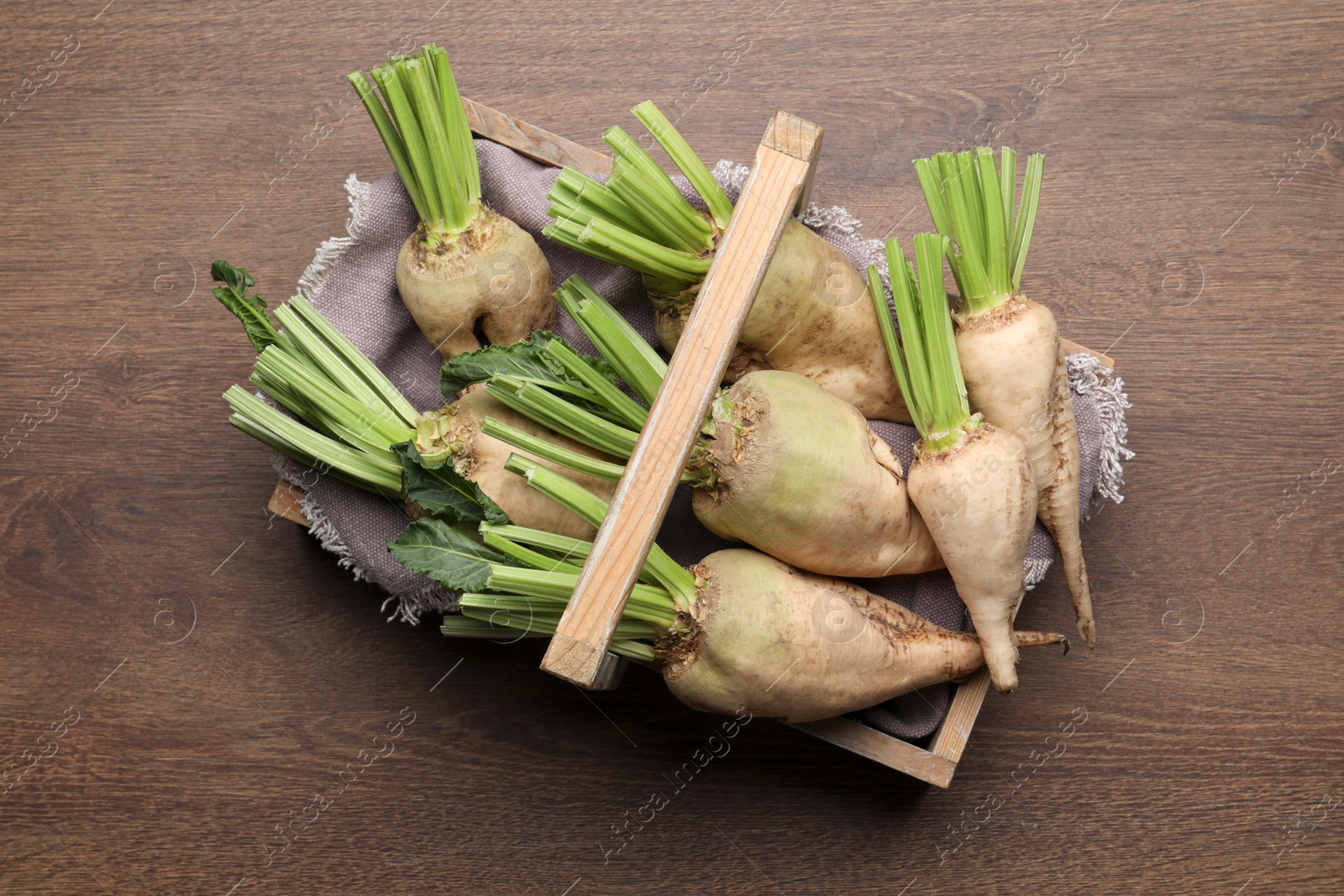 Photo of Basket with fresh sugar beets on wooden table, top view