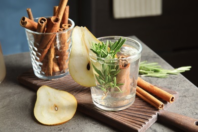 Photo of Tasty refreshing cocktail with rosemary and cinnamon on table