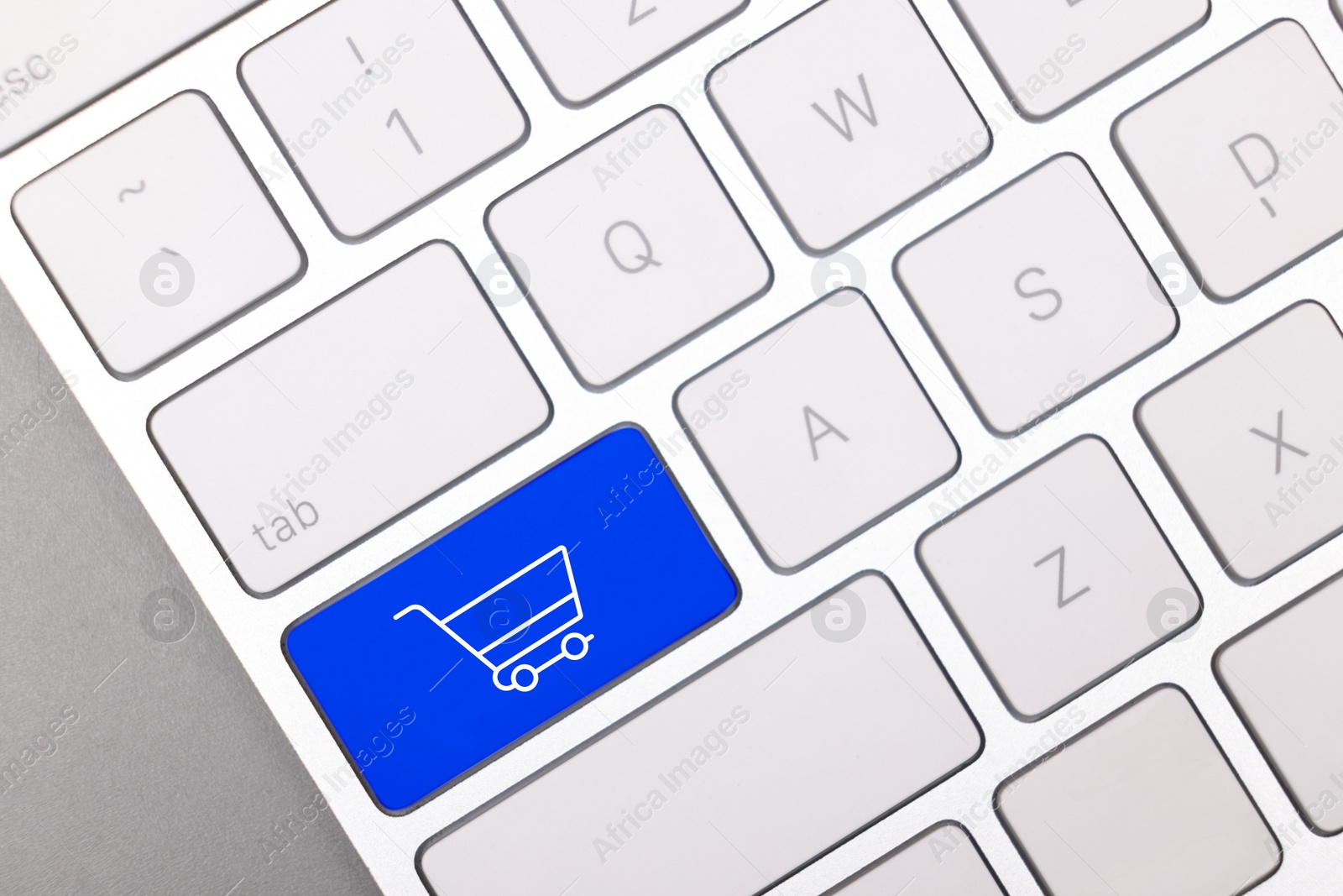 Image of Internet store. Blue button with shopping cart on computer keyboard, top view