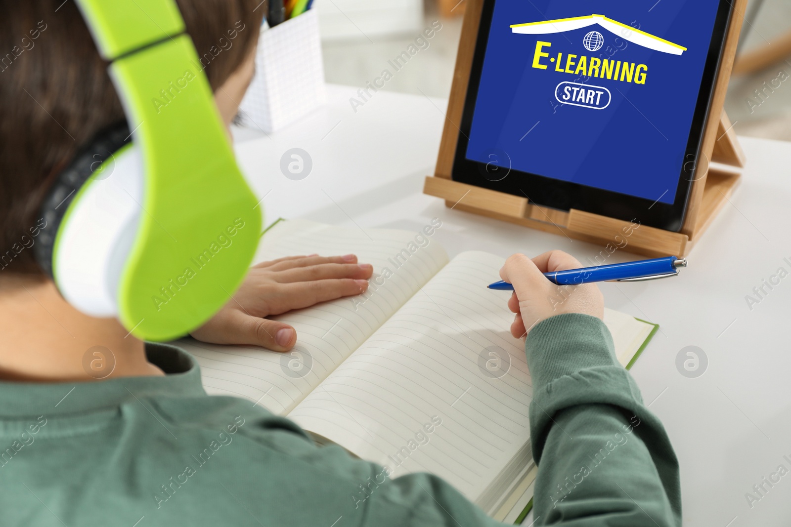 Image of Cute little boy with modern tablet studying online at home, closeup. E-learning