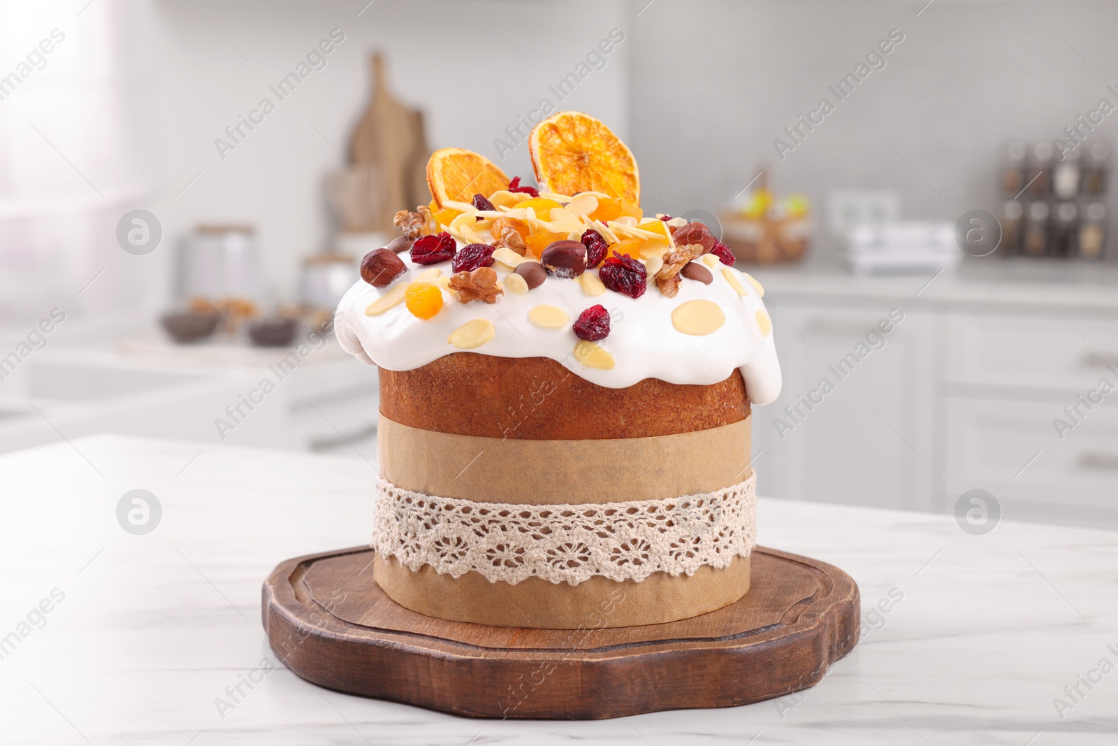 Photo of Delicious Easter cake with dried fruits on white marble table in kitchen