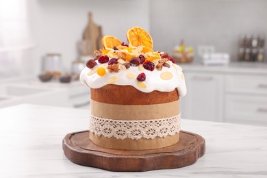 Delicious Easter cake with dried fruits on white marble table in kitchen