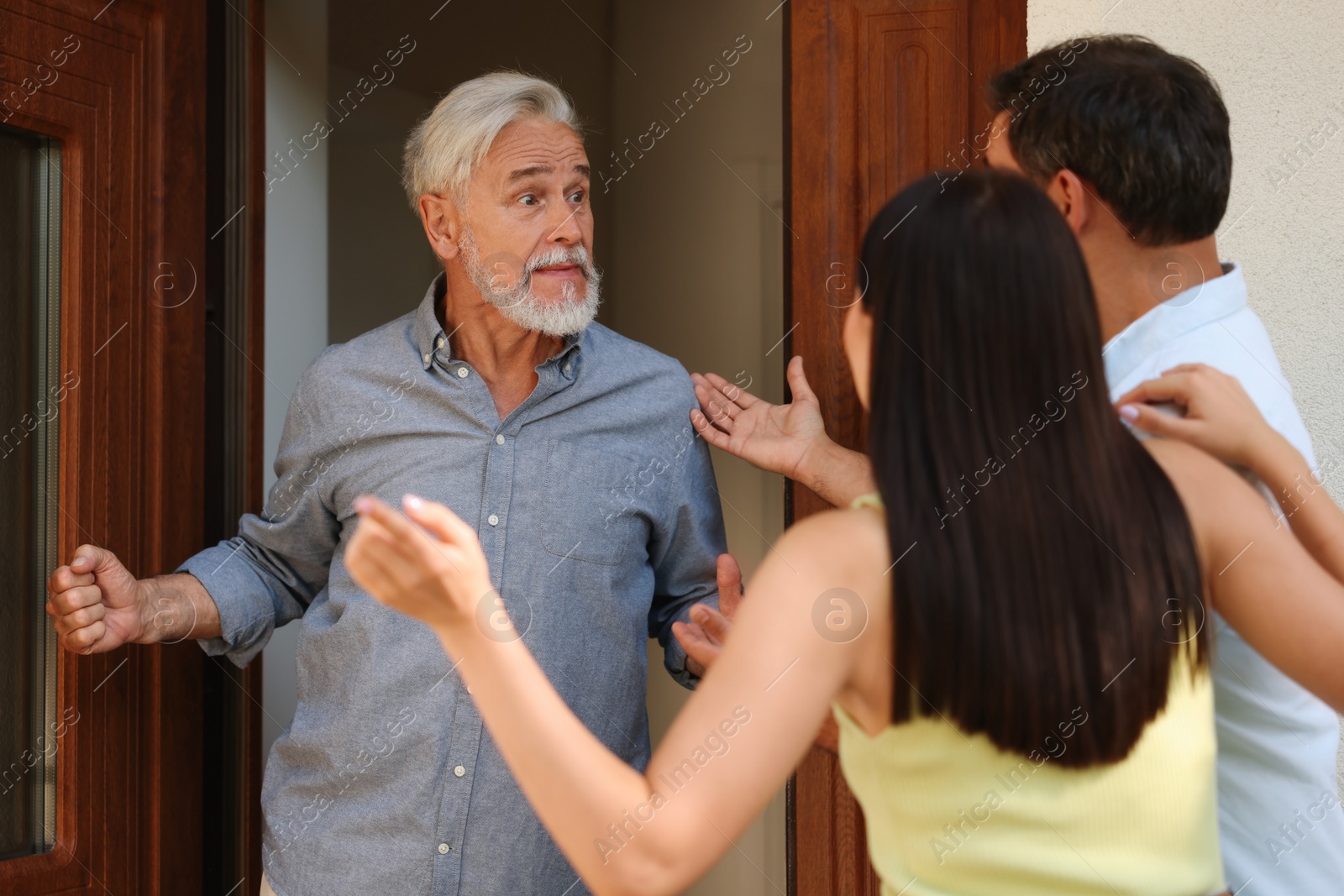 Photo of Neighbour`s quarrel. Young couple arguing with emotional senior man