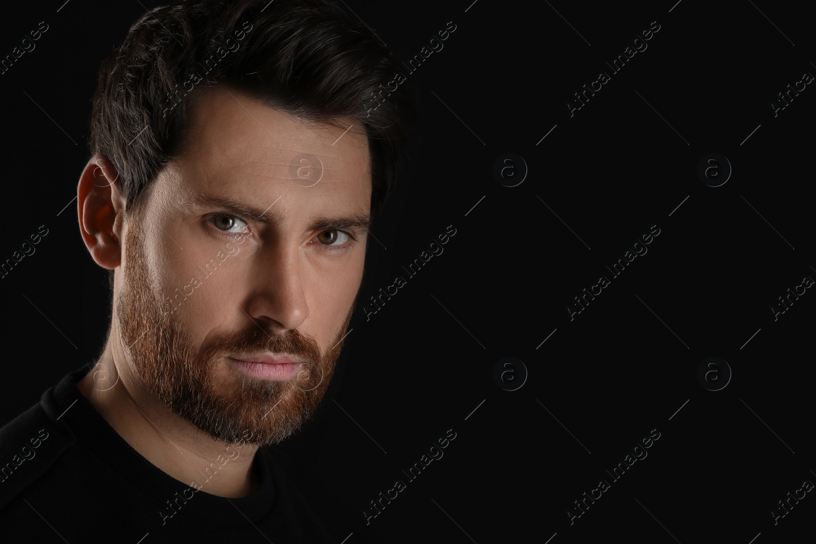 Photo of Evil eye. Man with scary eyes on black background, closeup and space for text