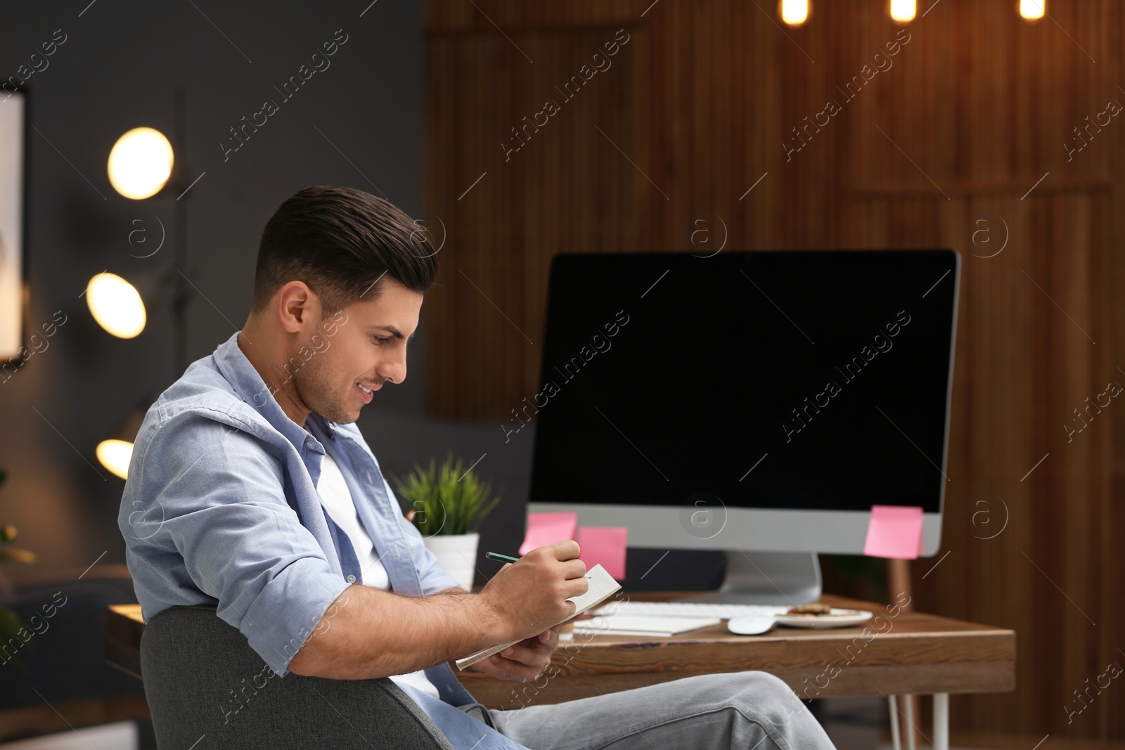 Photo of Male employee at desk in office. Corporate worker