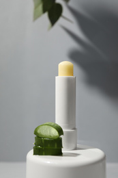 Hygienic lipstick and cut aloe vera leaf on light table
