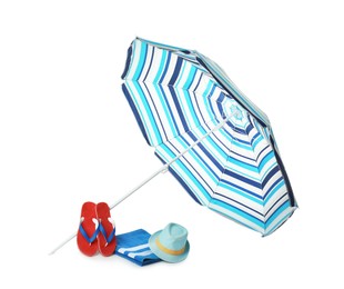Photo of Open striped beach umbrella, towel, flip flops and hat on white background