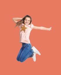 Image of Happy cute girl jumping on coral background