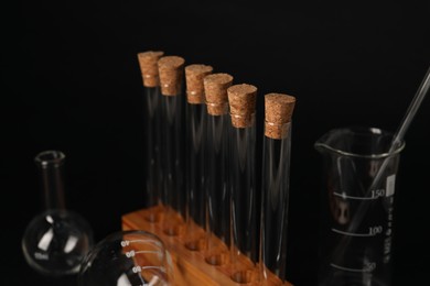 Photo of Different laboratory glassware on black background, closeup