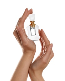 Woman holding bottle of luxury perfume on white background, closeup