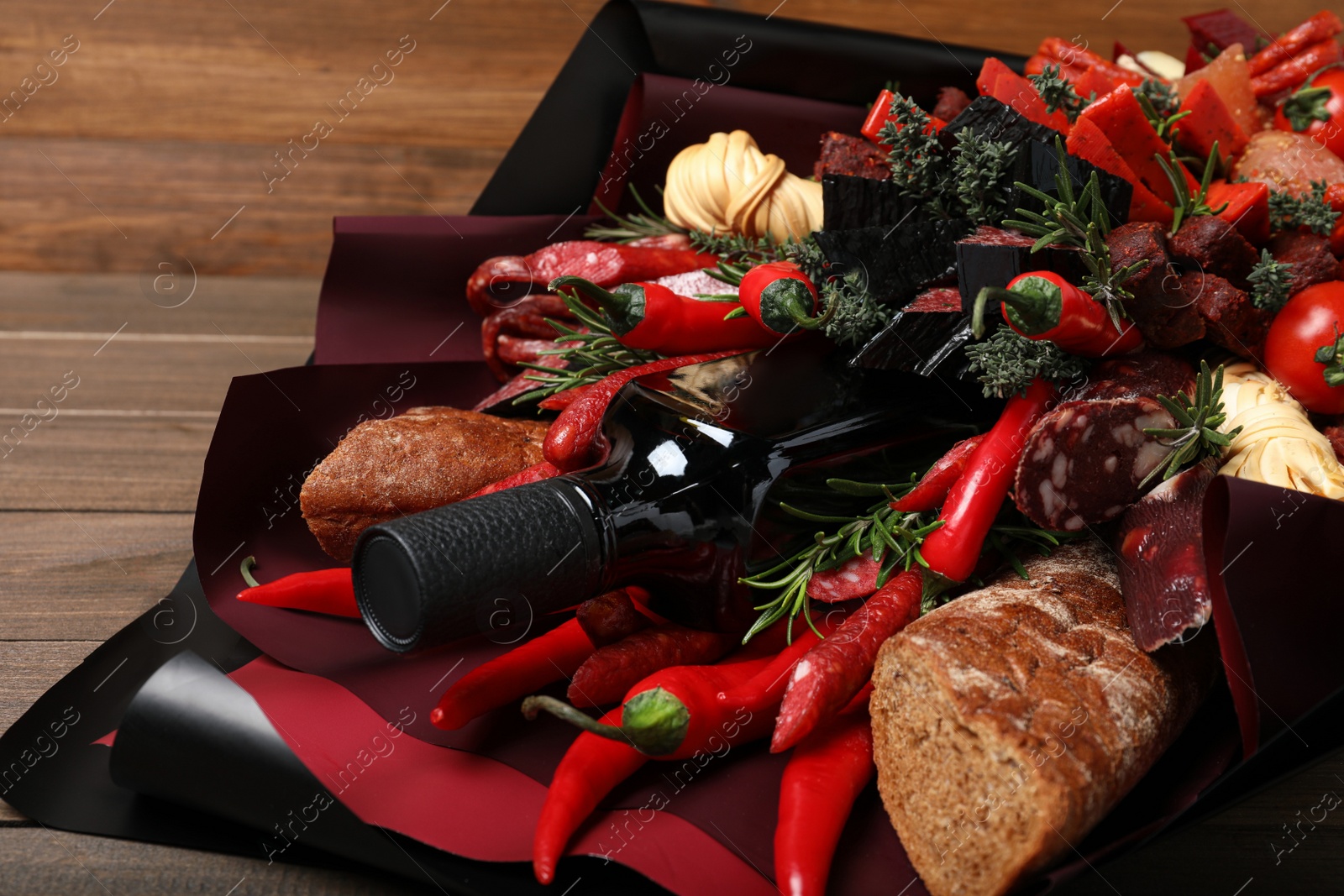 Photo of Beautiful edible bouquet with meat, cheese and vegetables on wooden table, closeup