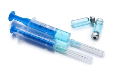 Photo of Disposable syringes with needles and vials on white background