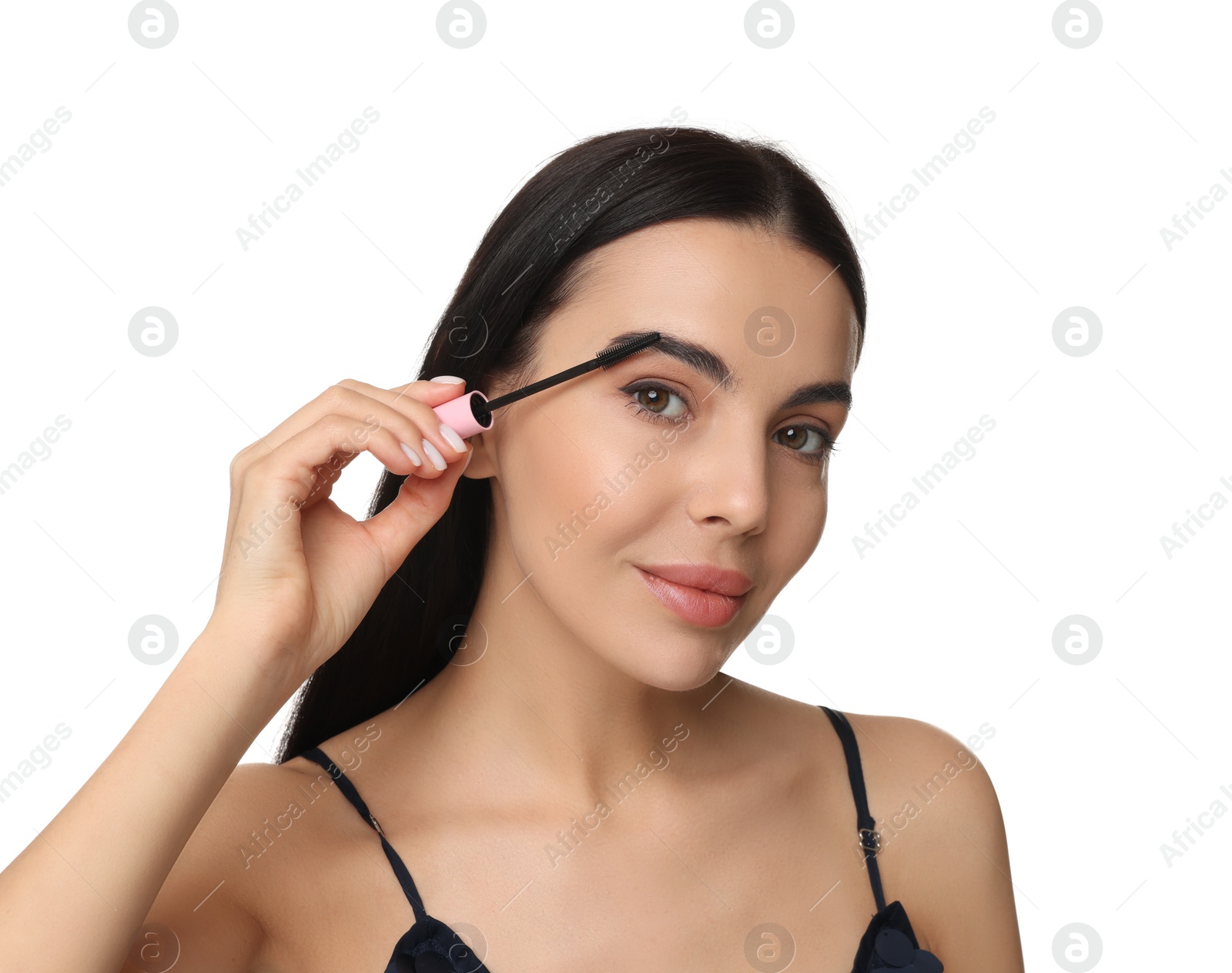 Photo of Beautiful young woman applying mascara on white background