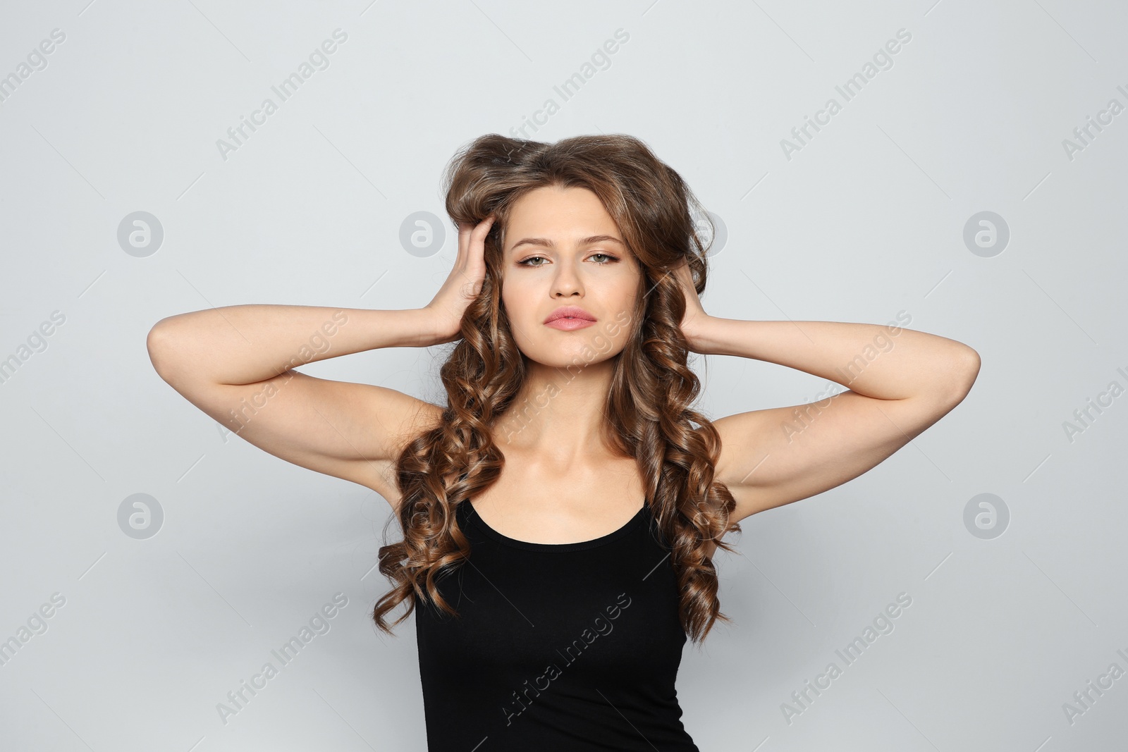 Photo of Portrait of beautiful young woman with shiny wavy hair on color background
