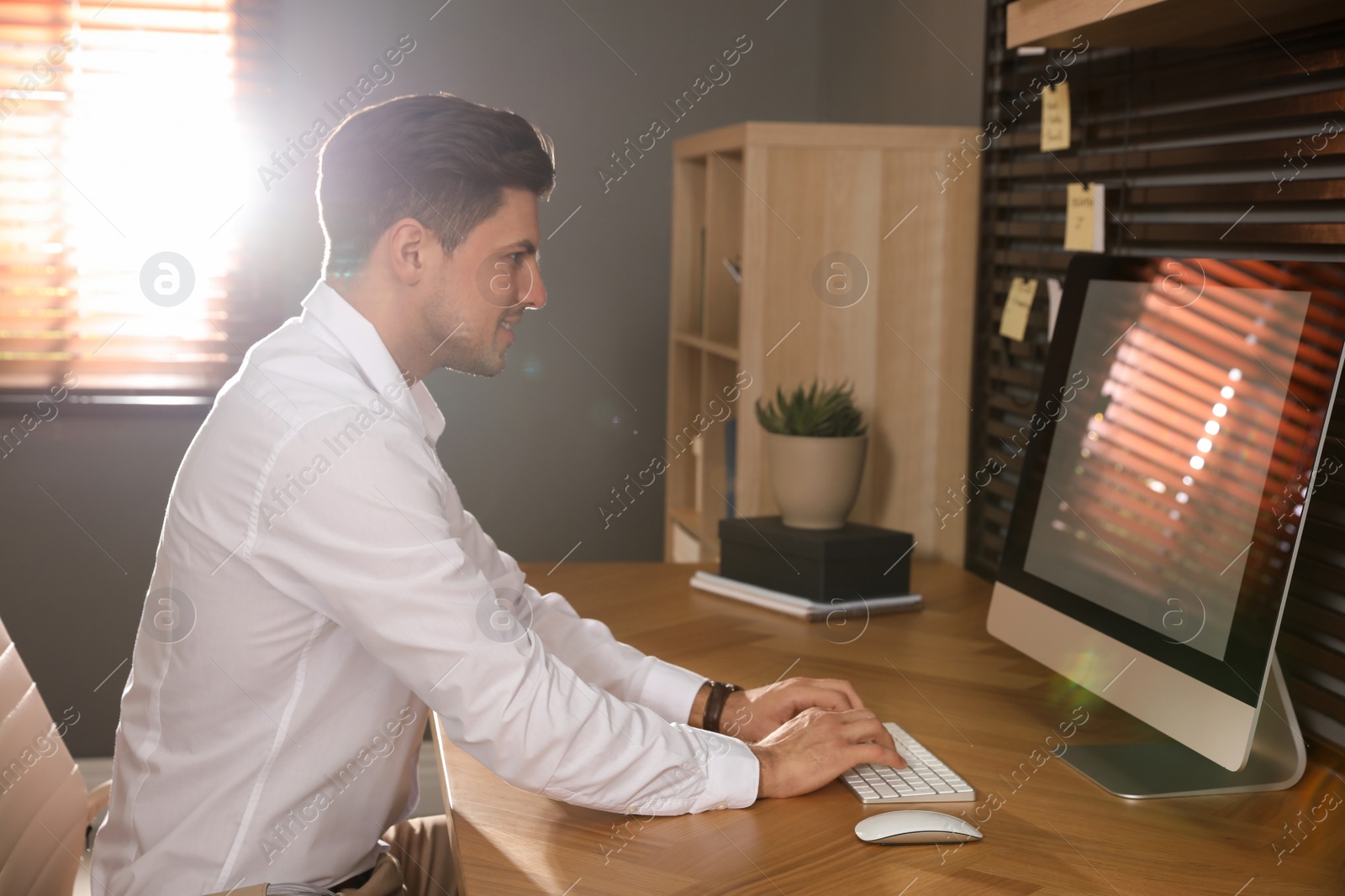 Photo of Man sitting at comfortable workplace with modern computer