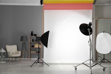 Photo of White photo background and professional lighting equipment in modern studio