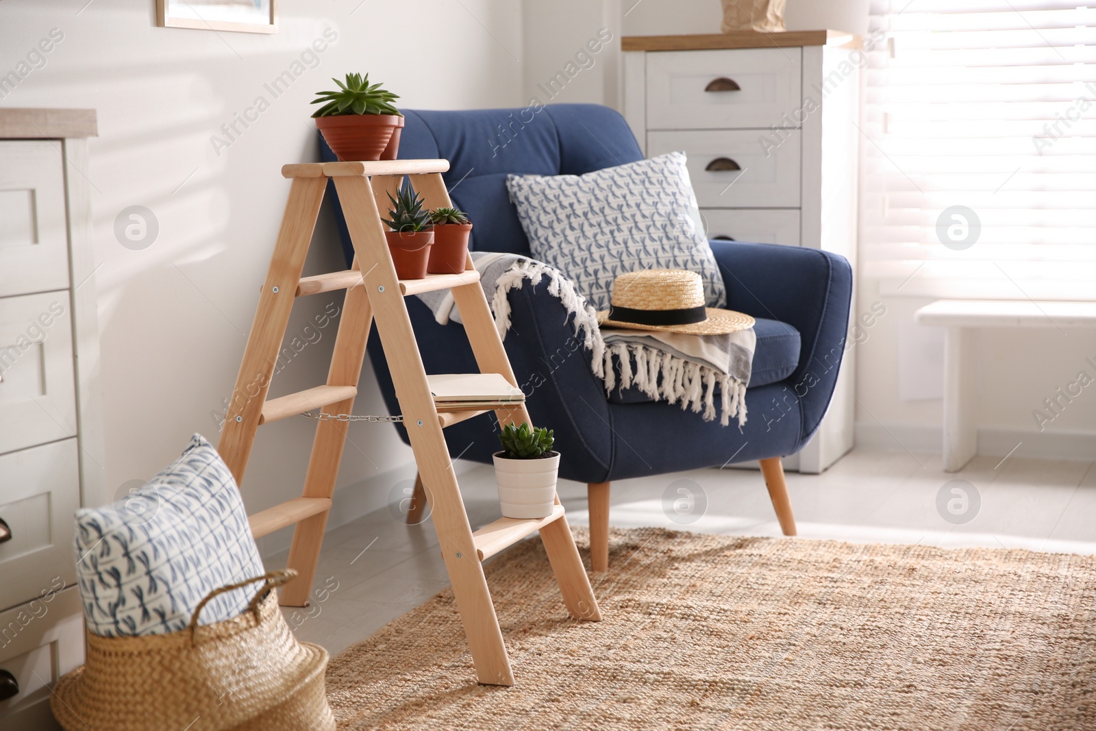 Photo of Stylish living room interior with wooden ladder and comfortable armchair