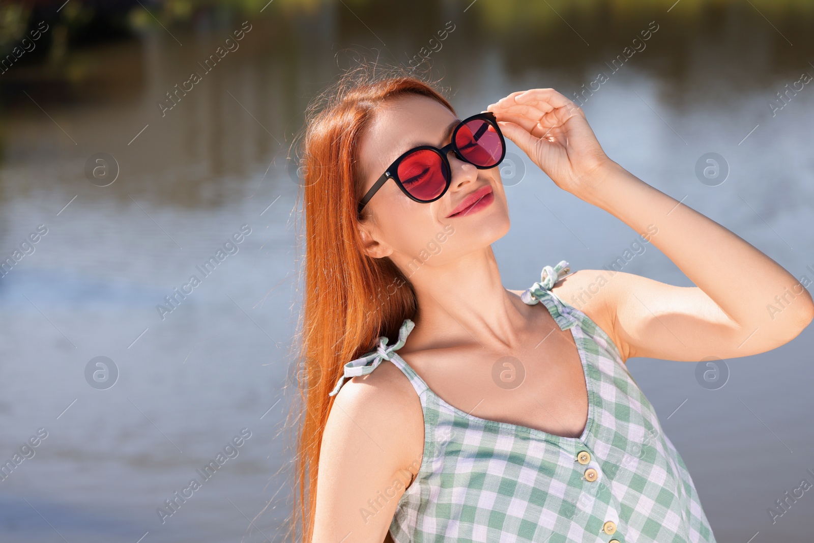 Photo of Beautiful woman in sunglasses near river, space for text