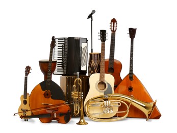 Photo of Set of different musical instruments and microphone on white background