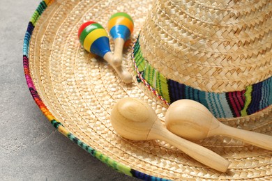 Mexican sombrero hat and maracas on grey textured table