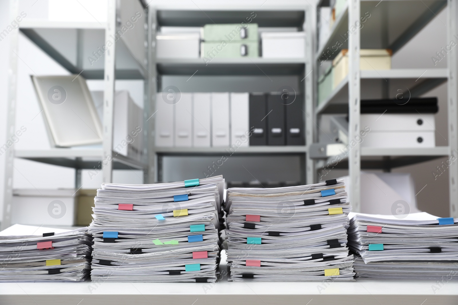 Photo of Stacks of documents with paper clips on office desk