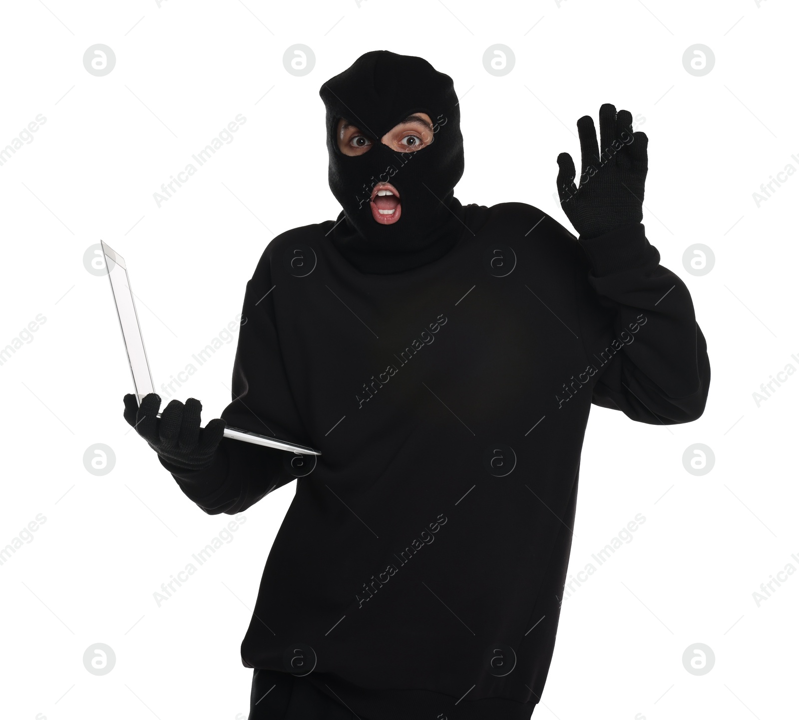 Photo of Emotional thief in balaclava with laptop raising hand on white background