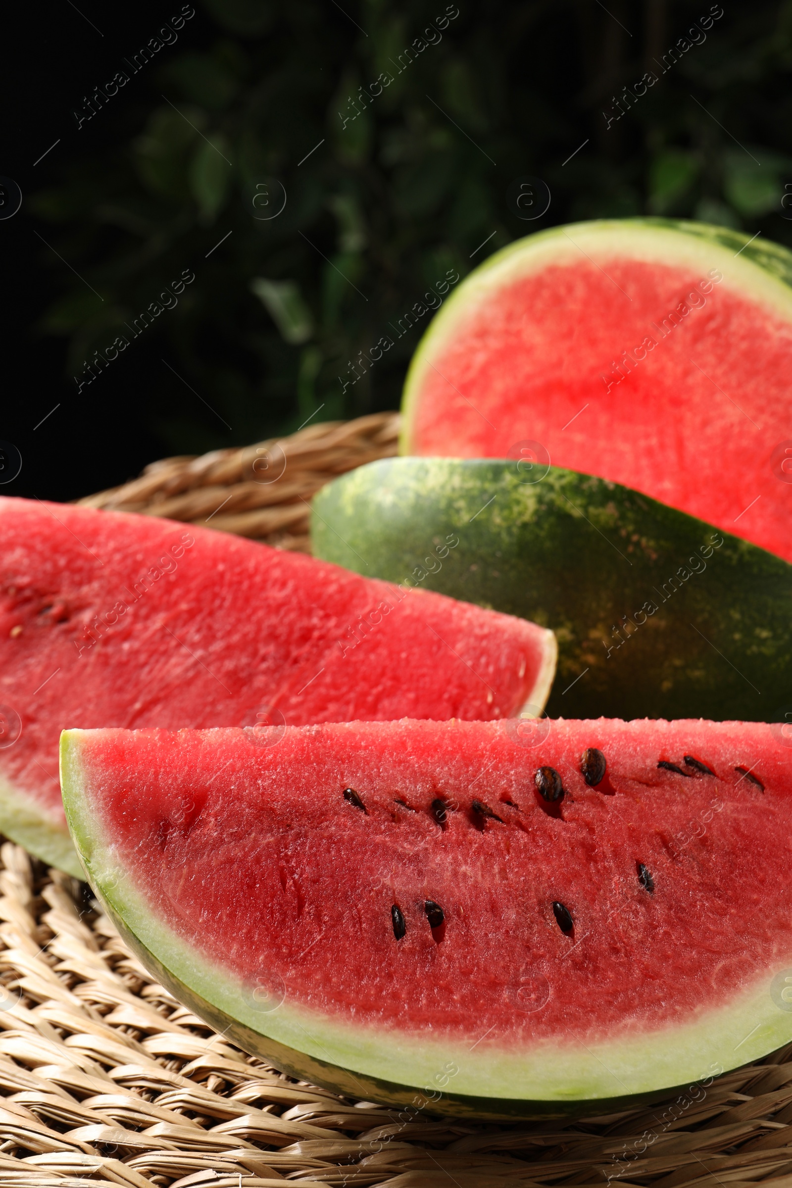 Photo of Delicious fresh watermelon slices on wicker mat, closeup