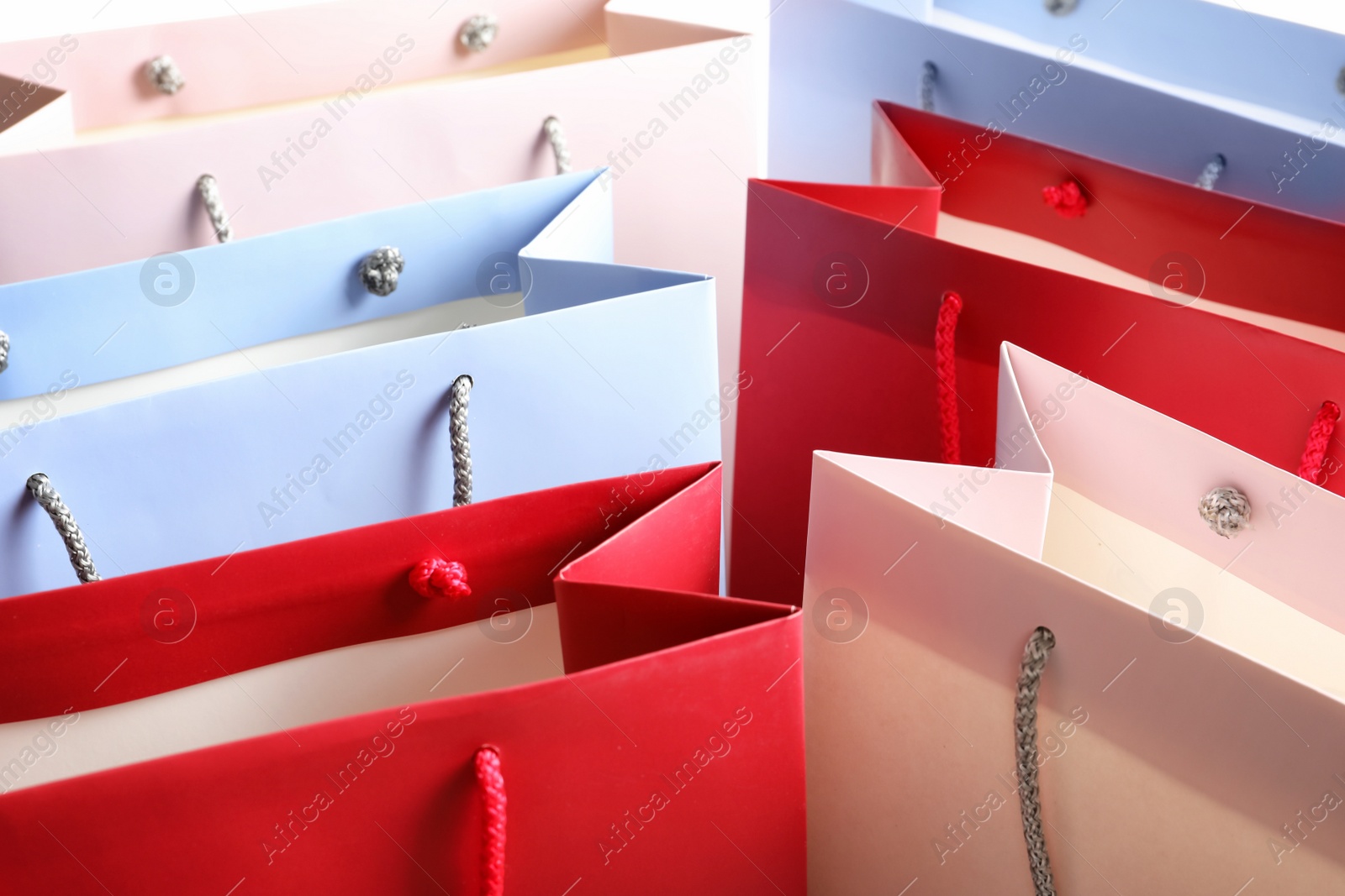 Photo of Colorful paper shopping bags as background, closeup