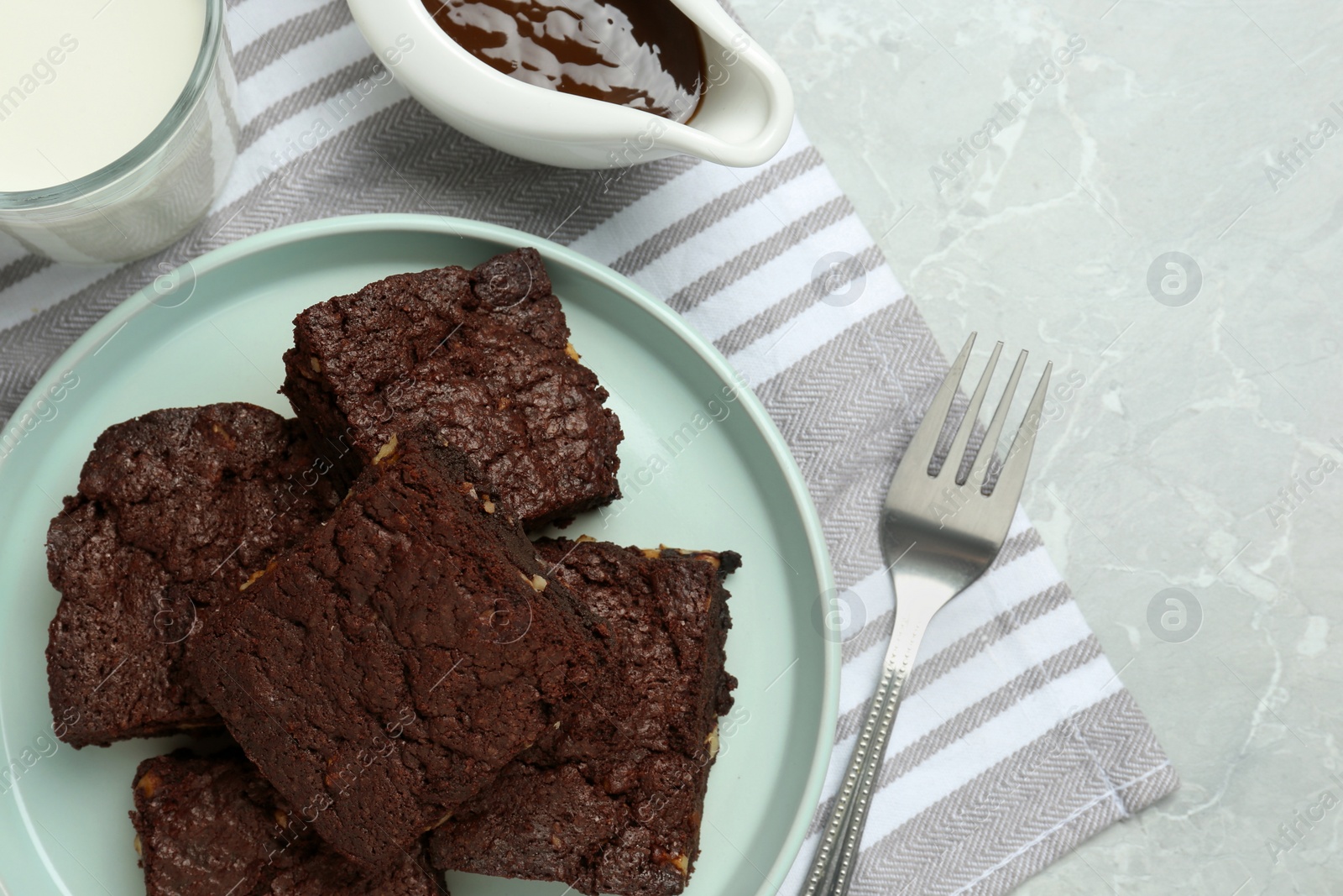 Photo of Delicious chocolate brownies with nuts on light grey table, flat lay