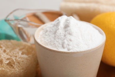 Photo of Bowl with baking soda and cleaning items on plate, closeup