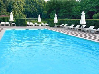 Photo of Outdoor swimming pool in luxury hotel on sunny summer day. Time for relax