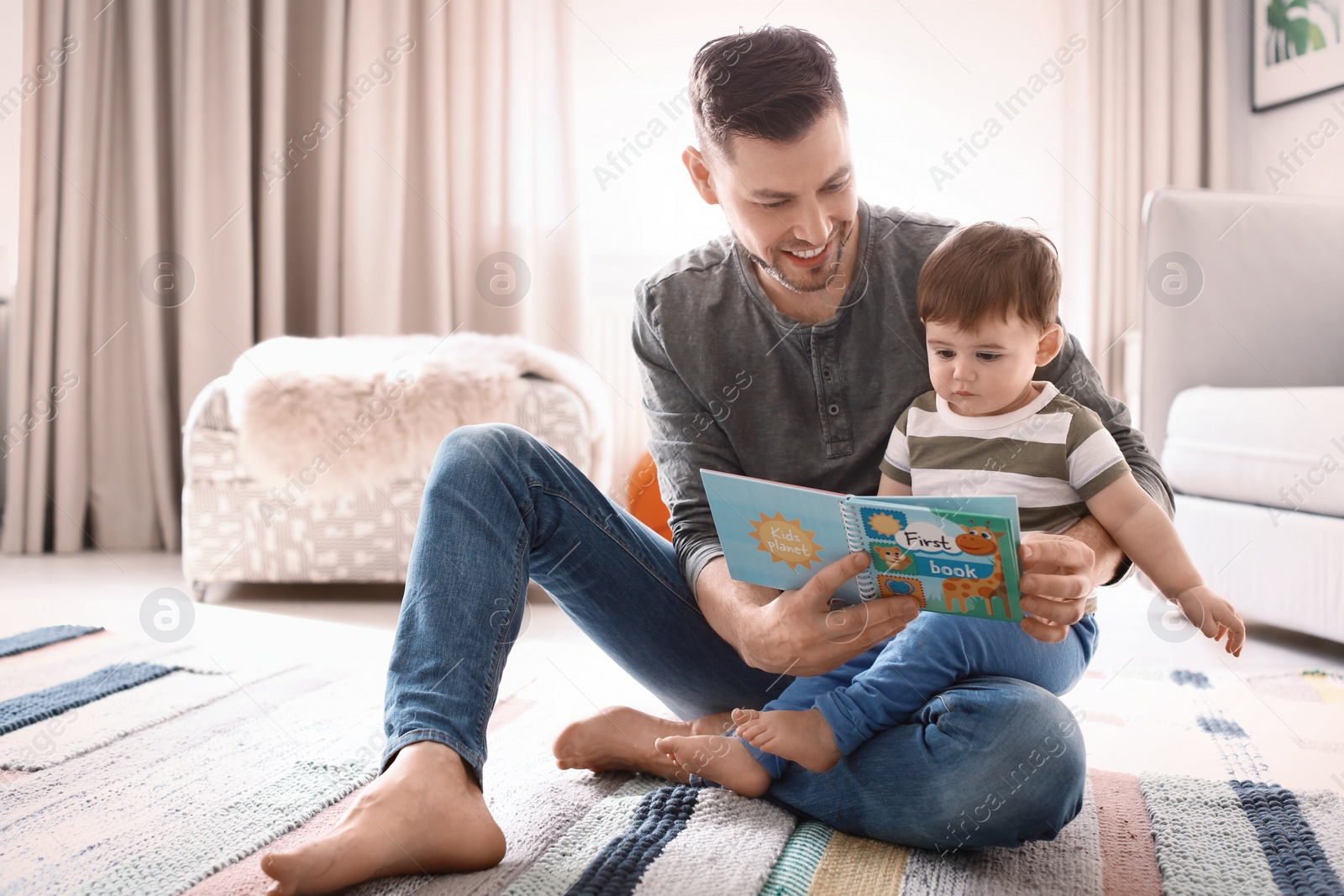 Photo of Dad and his son reading book at home