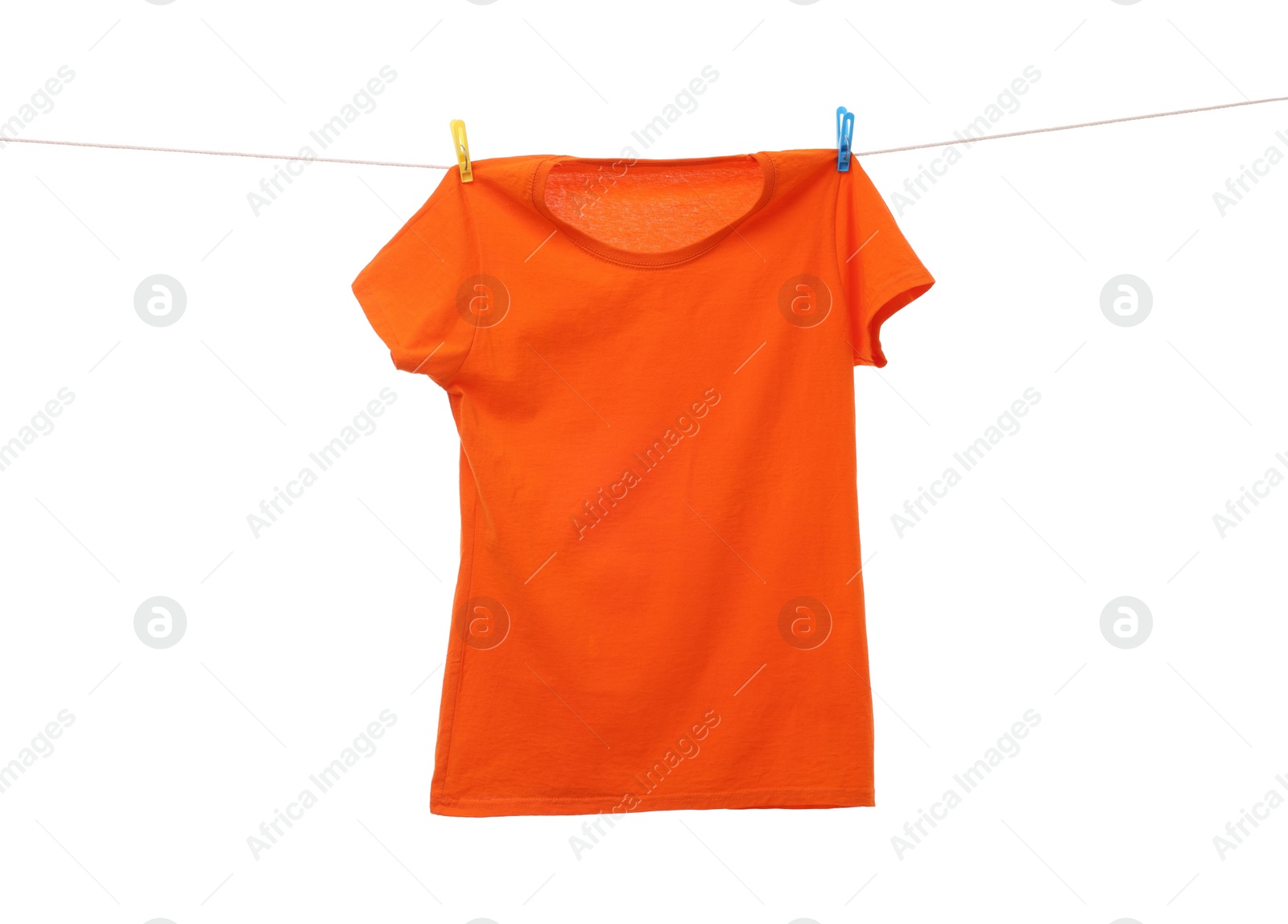 Photo of One orange t-shirt drying on washing line isolated on white