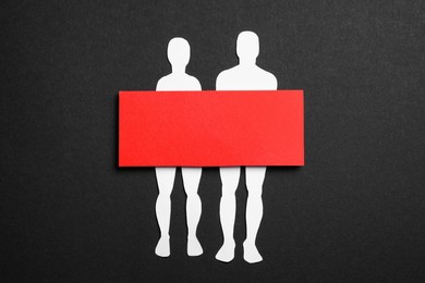 Photo of Couple figure cutout with censor bar on black background, top view