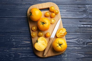 Ripe yellow tomatoes on blue wooden table, top view