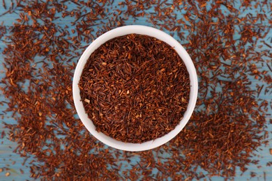 Photo of Dry rooibos leaves on turquoise wooden table, flat lay