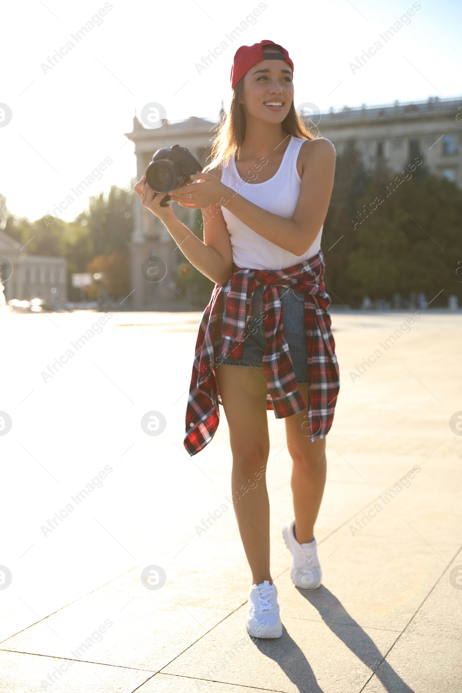 Photo of Young photographer with professional camera on city street