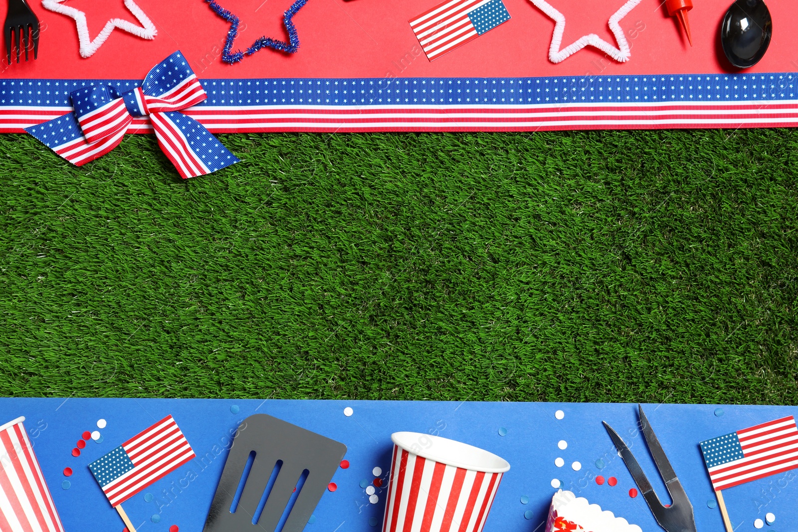 Photo of Flat lay composition with barbecue tools on green grass, space for text. USA Independence Day