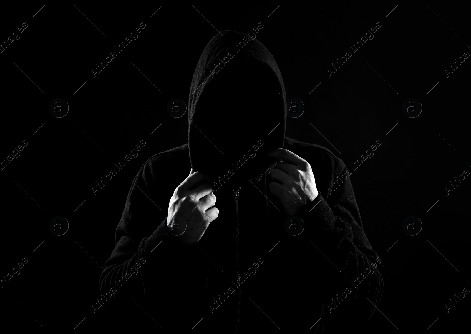 Image of Anonymous man in hood on black background