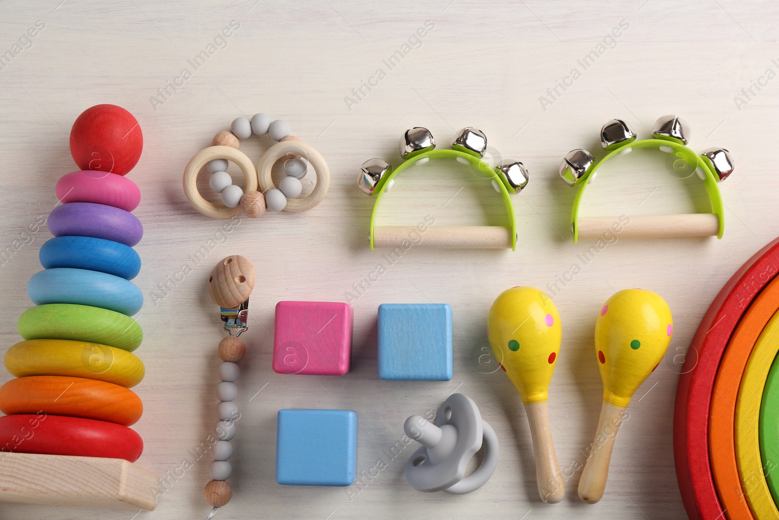 Photo of Baby song concept. Flat lay composition with toy musical instruments on white wooden background