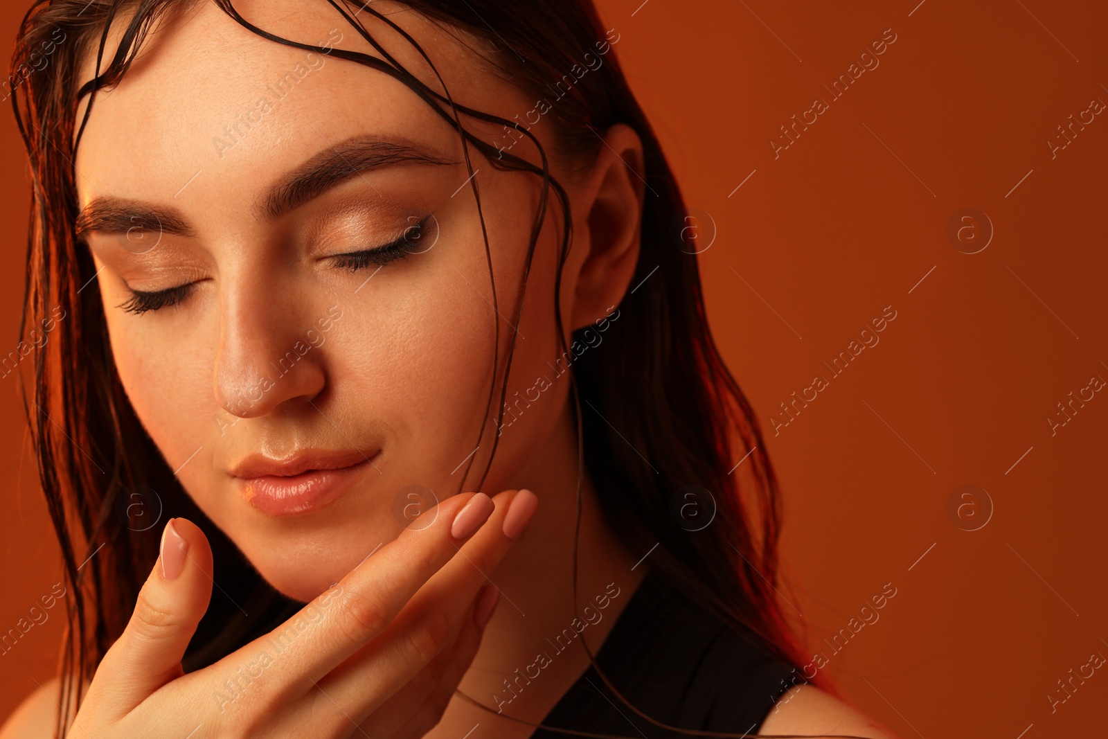 Photo of Portrait of beautiful woman on brown background, closeup. Space for text