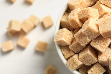 Photo of Brown sugar cubes on white table, top view. Space for text