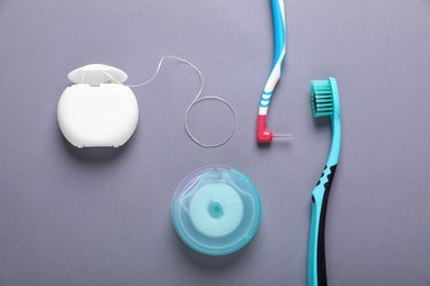 Photo of Flat lay composition with dental floss and different teeth care products on grey background